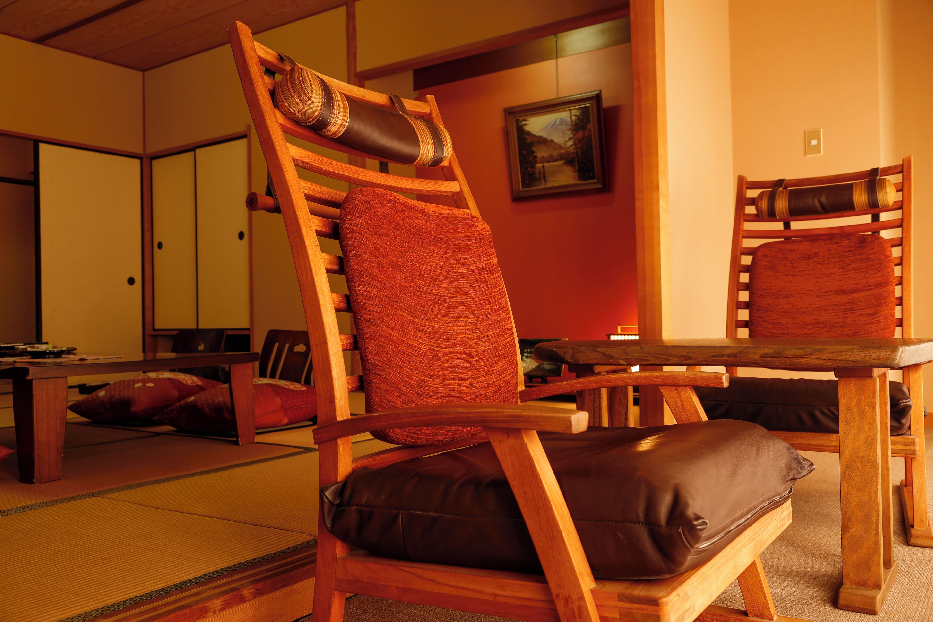 Um quarto japonês tradicional com tatame, uma mesa de madeira e uma cadeira de madeira baixa com almofada.