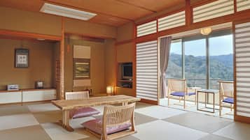Ett traditionellt japanskt rum med tatamimattor på golvet, ett lågt träbord och en tv.