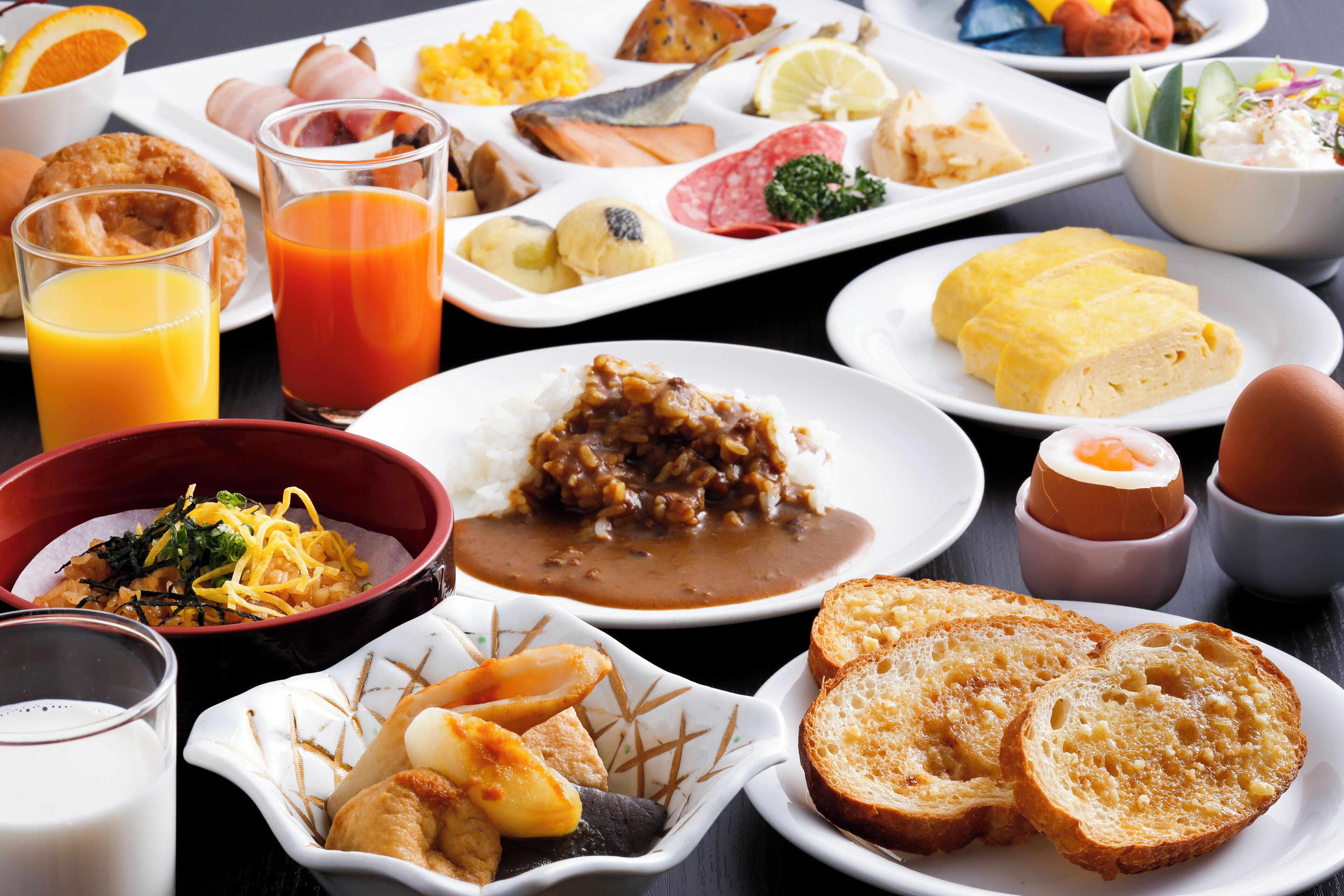 A variety of breakfast dishes including eggs, toast, and fruit.