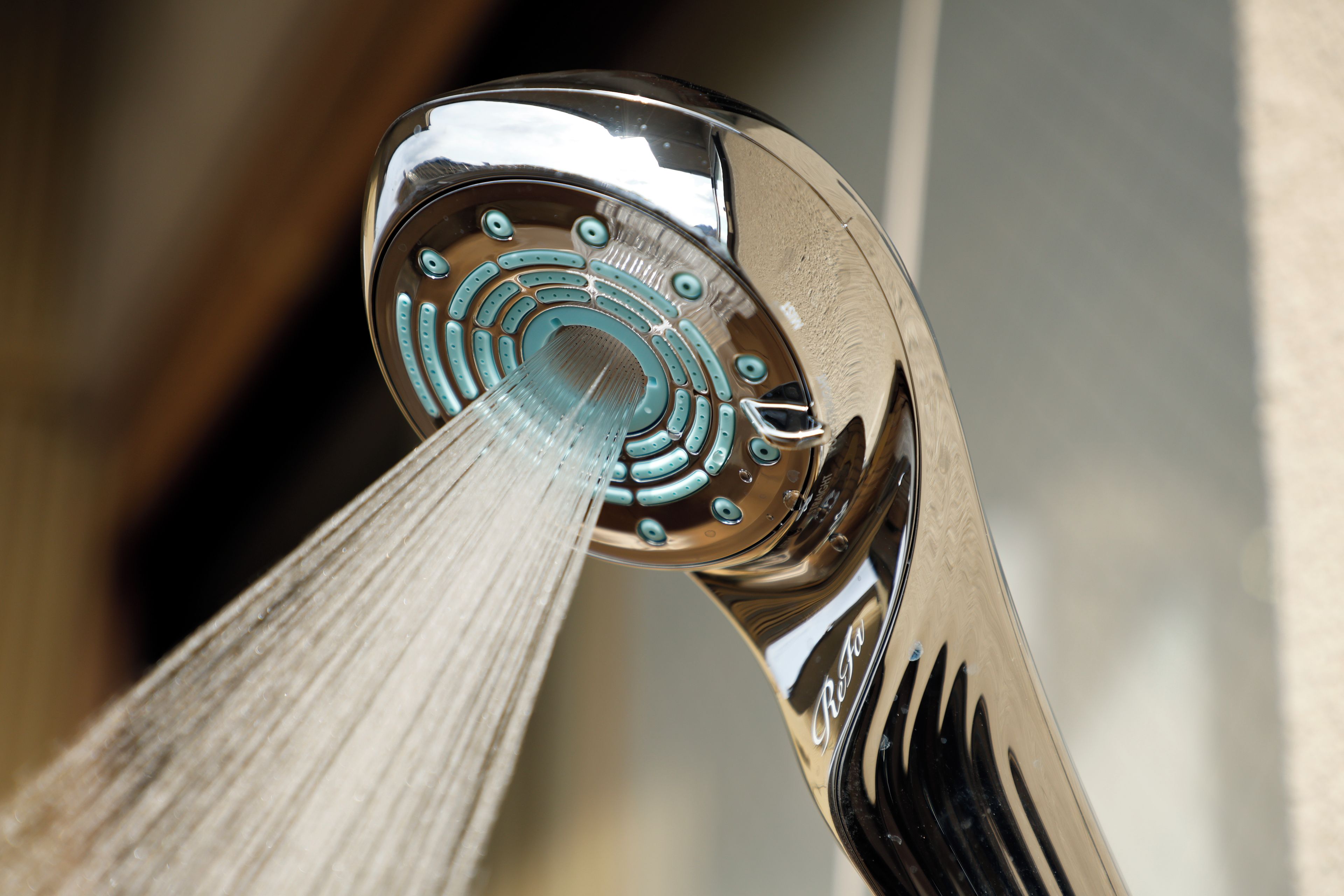A chrome faucet with a modern design, featuring a circular pattern and multiple control holes.