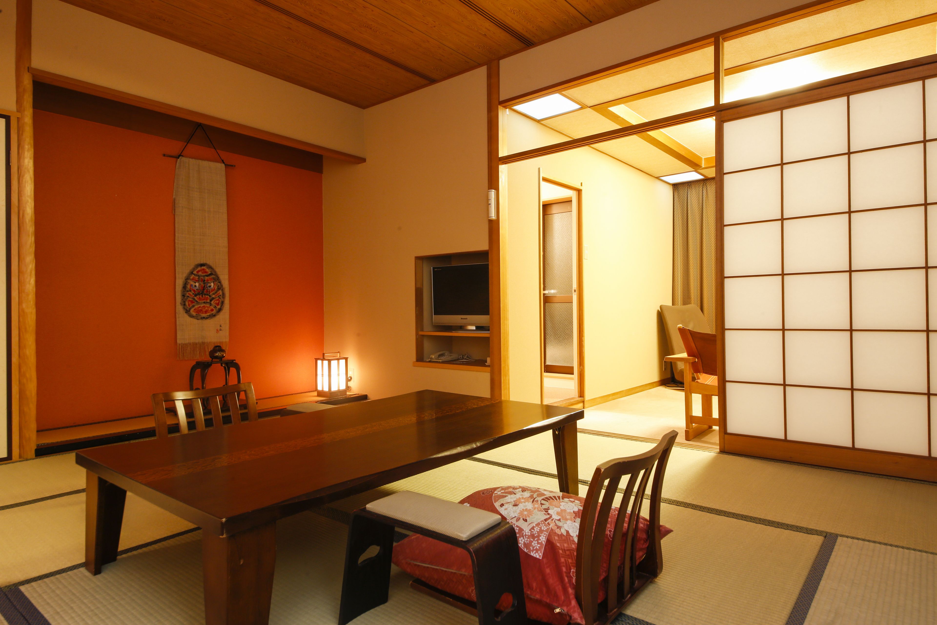 A traditional Japanese room with tatami flooring, a low wooden table, and a sliding shoji screen.