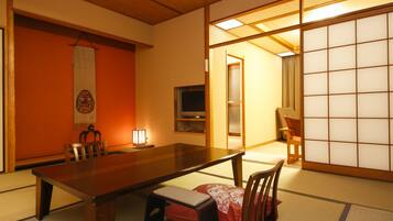A traditional Japanese room with tatami flooring, a low wooden table, and a sliding shoji screen.