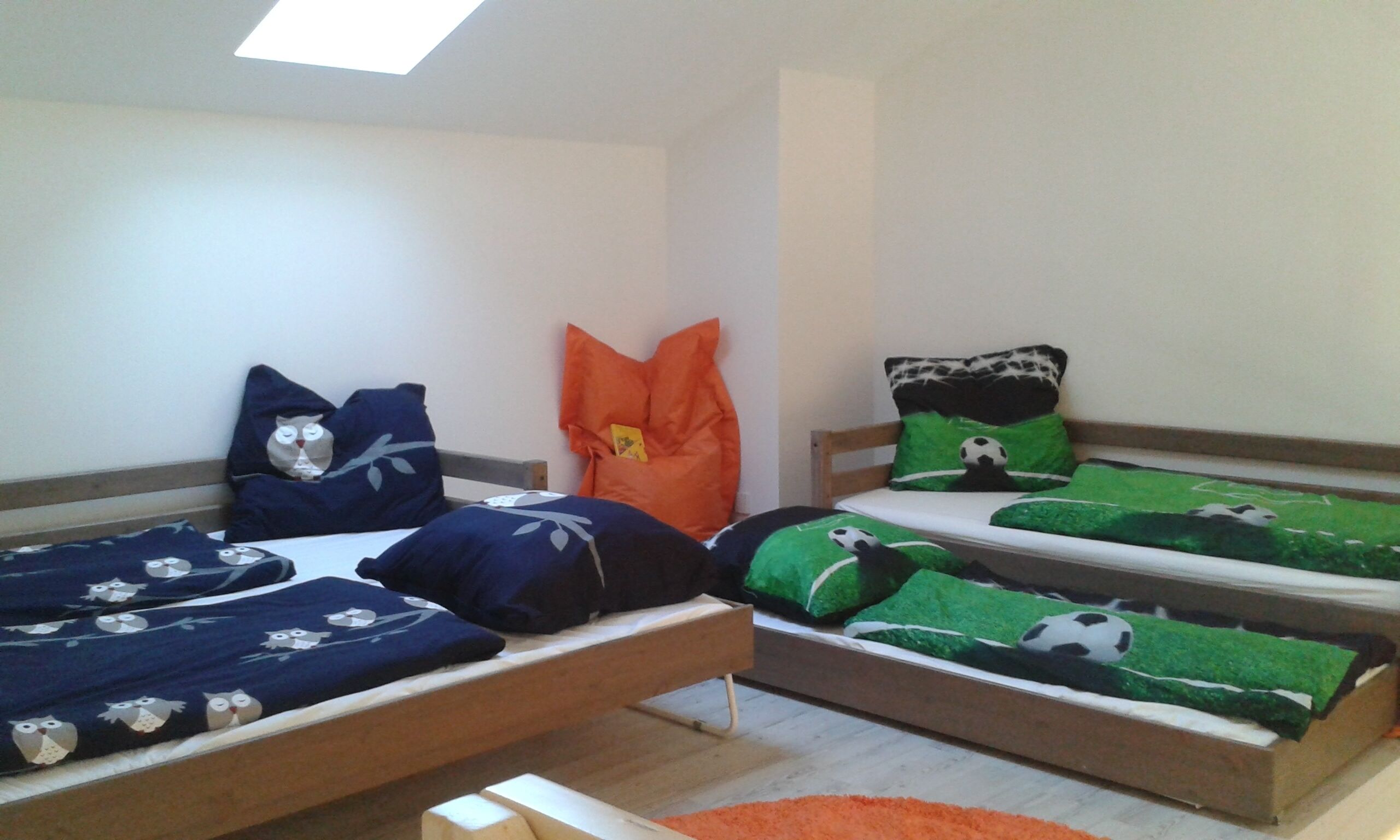 Une chambre avec trois lits, chacun ayant une literie sur un thème différent.