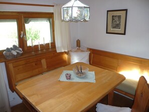 Ein Holztisch mit weißer Tischmatte, Kerzen und einer Glaskugel.