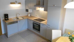 Cocina compacta con lavamanos, estufa y microondas.