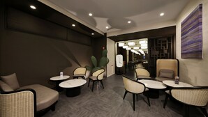 A modern lounge area with sofas, chairs, and tables arranged for socializing. - Doutonbori Crystal Hotel (Osaka)