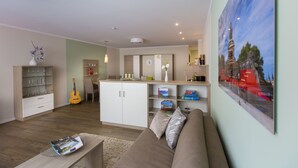 Ein modernes Wohnzimmer mit Sofa, Couchtisch und Bücherregal.