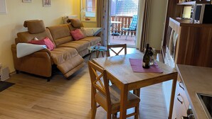 Un espacio de sala acogedor con un sofá, una mesa de comedor y una cocina.