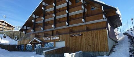 A wooden lodge with a sign reading "STARS PHOTO" and "La Laviole".