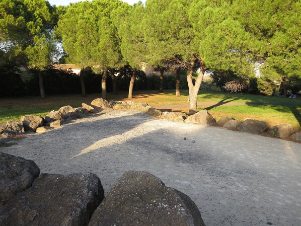A gravel area with large rocks and trees in the background.