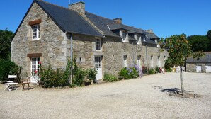 Un bâtiment en pierre doté de nombreuses fenêtres et d’une allée gravillonnée.