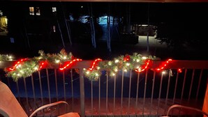 A balcony with metal railings, two wooden chairs, and a garland of lights. - Slopeside 2 Bedroom 2Bath-Great Value (Durango)