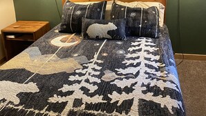 A bedroom with a large bed, two bedside lamps, a framed picture on the wall, and a small wooden nightstand. - Slopeside 2 Bedroom 2Bath-Great Value (Durango)
