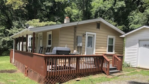 A single-story house with a covered porch and a small deck.