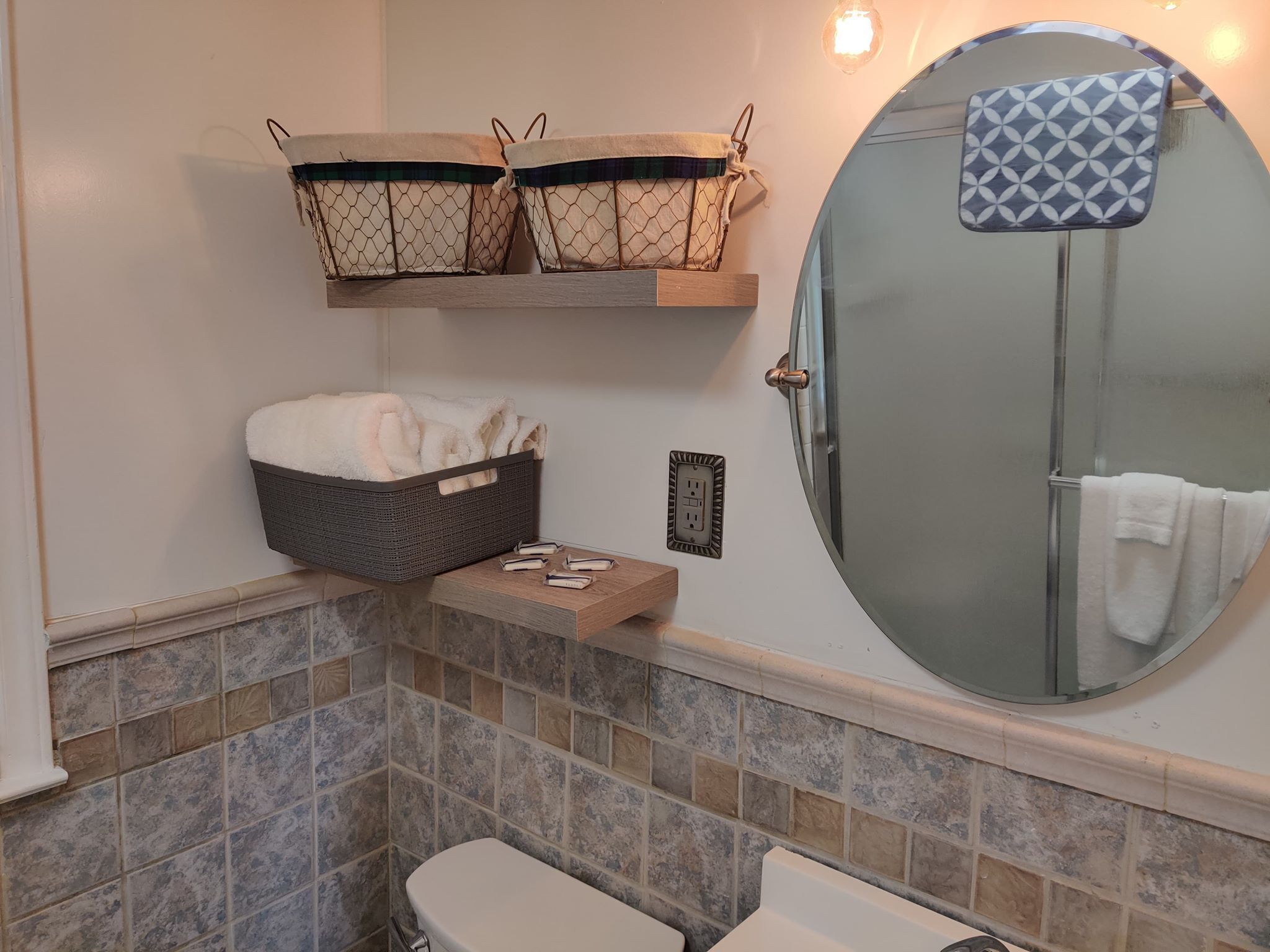 A bathroom with a toilet, a bidet, a towel rack, and a mirror.