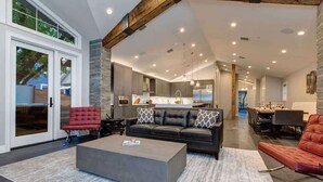 A modern living room with a grey sofa, red armchair, and a grey coffee table.