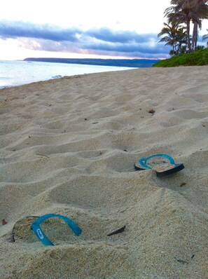 Una spiaggia sabbiosa con impronte e un oggetto blu.