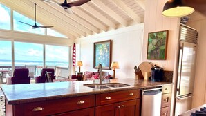 A kitchen with a large island, stainless steel appliances, and a view of the ocean. - BEACH FRONT ESTATE SANDY BEACH Heated Saline Pool 360 Views: Please Inquire (Waialua)