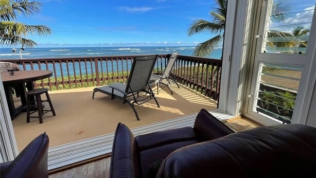 A balcony with a view of the ocean, furnished with a table, chairs, and a sofa. - BEACH FRONT ESTATE SANDY BEACH Heated Saline Pool 360 Views: Please Inquire (Waialua)