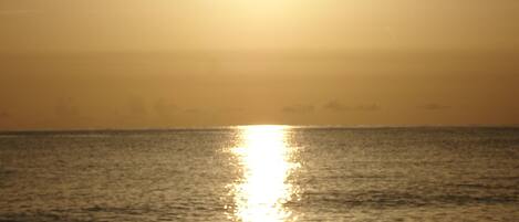 A sunset over the ocean with a clear sky.
