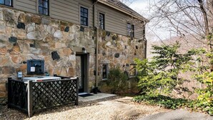 Edificio de piedra con un patio, una parrilla y una puerta.