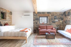 Relax in this inviting room with a large bed, a comfortable armchair, and a cozy coffee table.