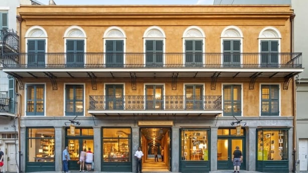 Un edificio de dos plantas con una tienda en la planta baja y balcones en el piso superior.