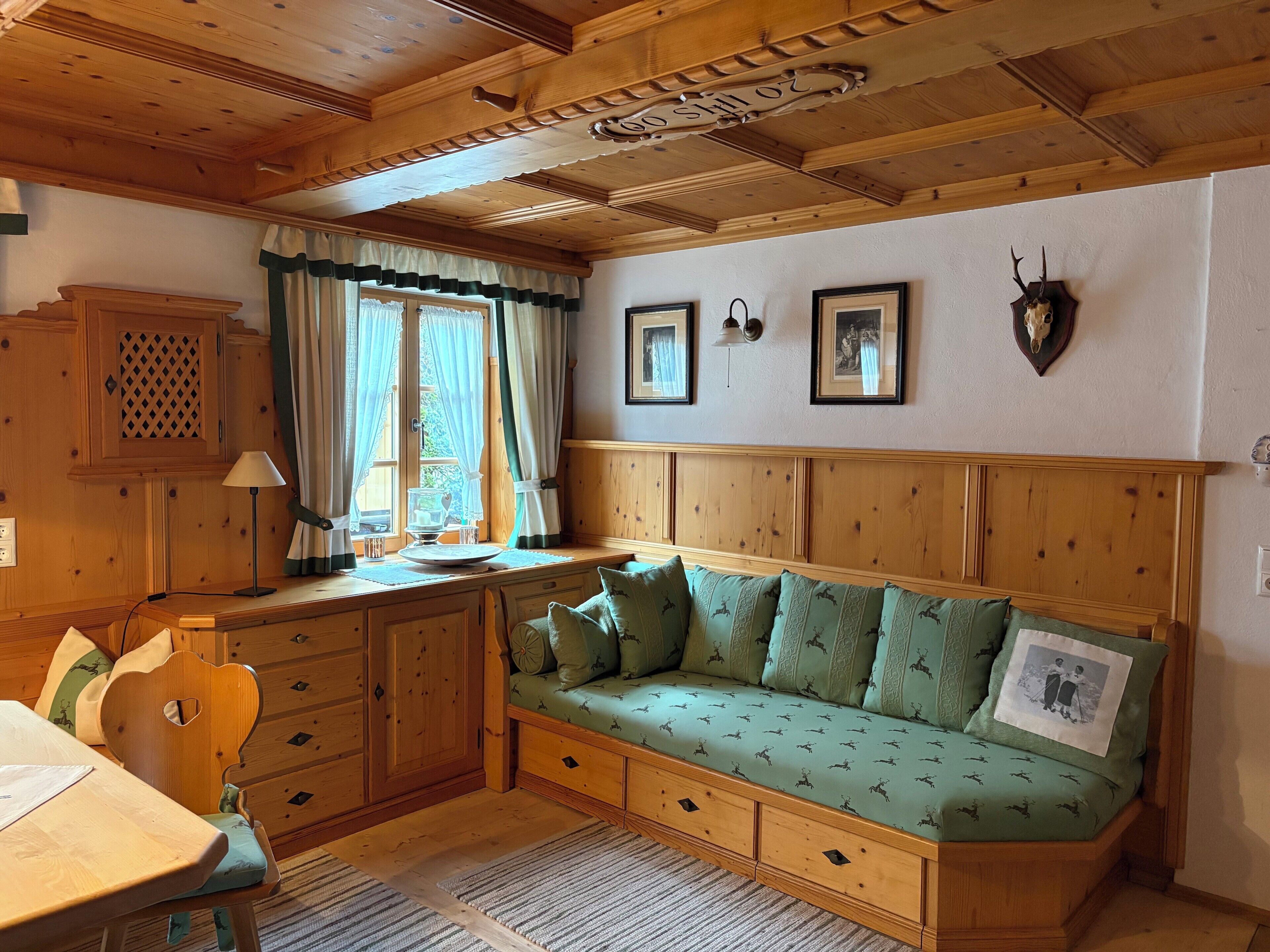 A cozy room with a wooden bench, a dining table, and a cabinet.