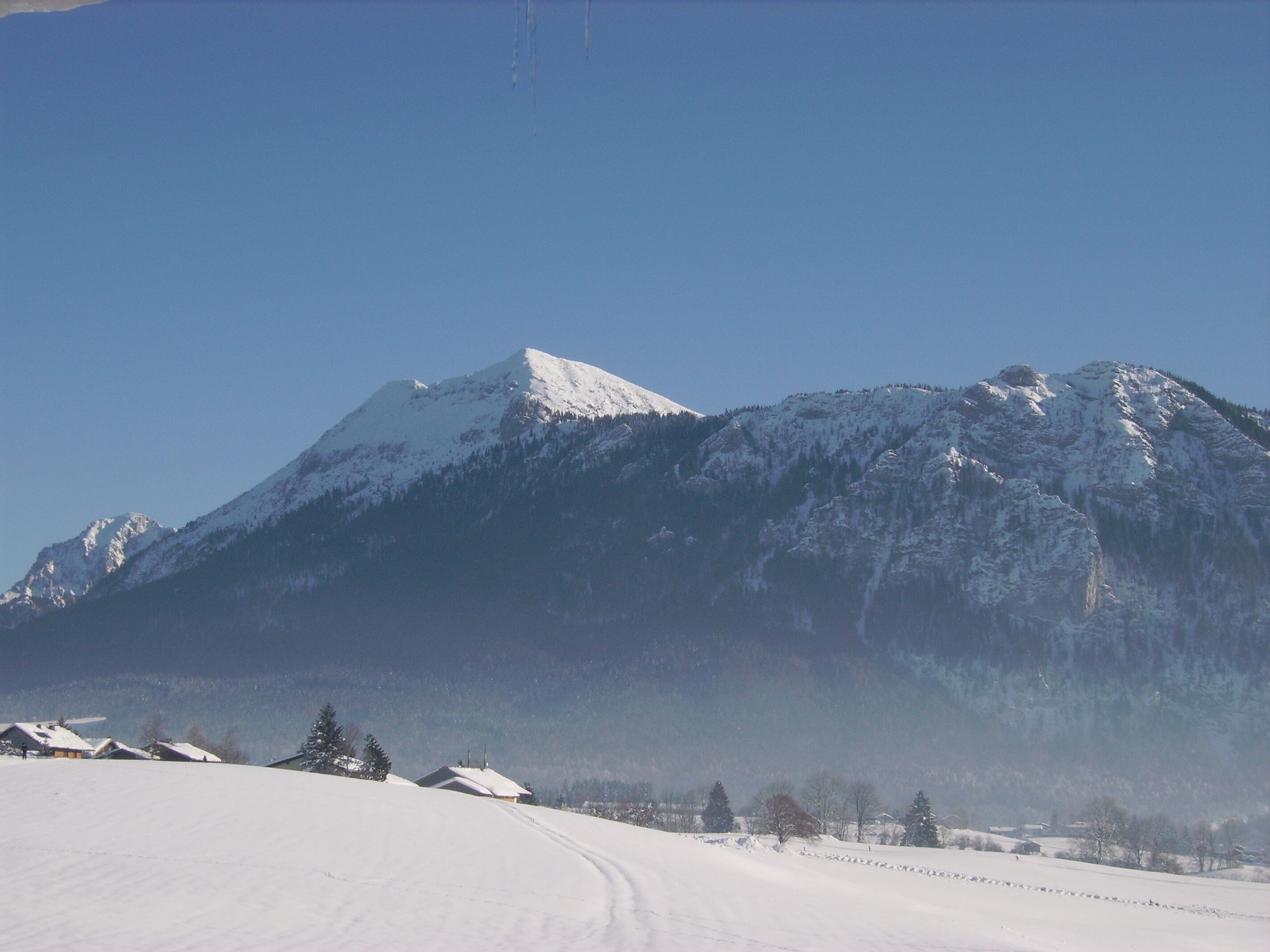 A snow-covered mountain with a clear sky.