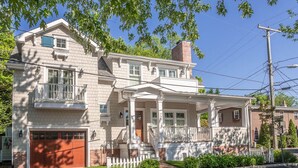 A two-story house with a front porch, a garage, and a brick chimney. - CORNER BEACH HOUSE - COTTAGE (Cape May)