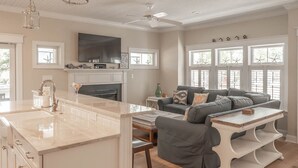 A spacious living area with a gray sofa, a coffee table, and a fireplace. - CORNER BEACH HOUSE - COTTAGE (Cape May)