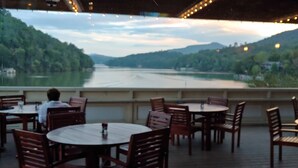 A restaurant with outdoor seating overlooking a river and hills. - Honeycrisp Cottage at Lake Lure NC. We have recovered from Hurricane Helene! (Lake Lure)