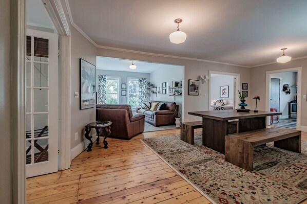 Un salón amplio con suelo de madera, una mesa de centro grande de madera y un sofá.