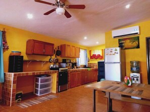 Enjoy cooking in this well-equipped kitchen with a sink, refrigerator, and ceiling fan.