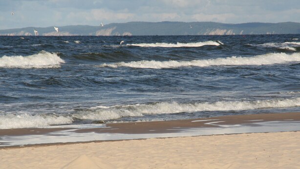 A beach with waves and distant mountains. - Modern, quiet vacation apartment (30 m²) with separate entrance near the beach  (Seebad Ahlbeck)