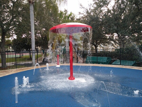 A water fountain with multiple jets in a park setting.