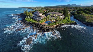 A coastal property with multiple buildings, a swimming pool, and a rocky shoreline. - Whalers Cove Unit #113 - Spectacular and Secluded Oceanfront Condo with Pool! (Koloa)