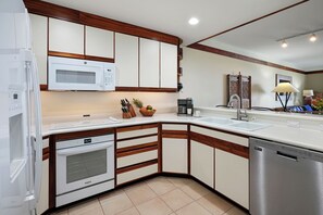 A modern kitchen with white cabinetry, a microwave, a coffee maker, and a dishwasher.