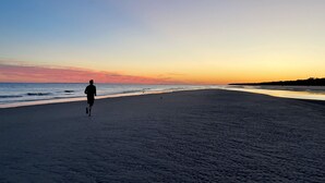 A beach with a person running. - Newly renovated cottage in Sea Pines. Private setting with a short walk to beach (Hilton Head Island)