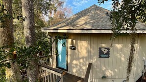 A small, single-story cabin with a 'Getaway' sign and a 'Home' sign, surrounded by trees. - Newly renovated cottage in Sea Pines. Private setting with a short walk to beach (Hilton Head Island)