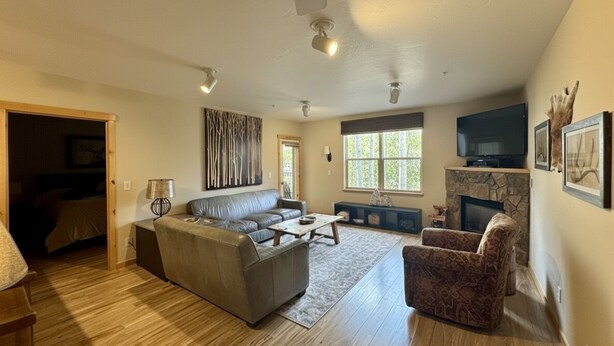 A spacious living room with a sofa, armchair, and a fireplace.