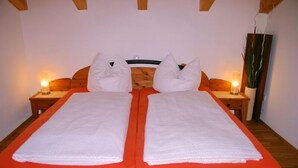 Una cama doble con dos almohadas y dos mesitas de noche con lámparas.
