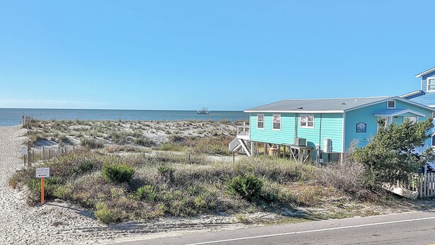 Una casa frente al mar con playa arenosa y vista al océano.