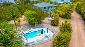 A pool area with a fenced deck, lounge chairs, and a small inflatable pool.