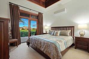 Une chambre avec un grand lit, deux tables de chevet avec des lampes, un banc, une armoire et une vue sur un immeuble par la fenêtre.