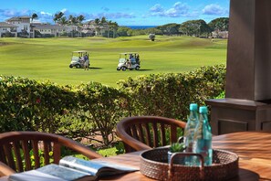 Une vue sur un terrain de golf avec deux voiturettes de golf et un bâtiment situé au loin.