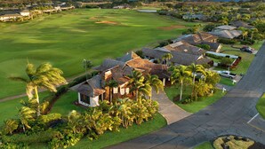 A golf course with houses, palm trees, and a clear view of the ocean. - Hale Lani - Custom Built Ocean view Home on Golf Course with A/C (Koloa)
