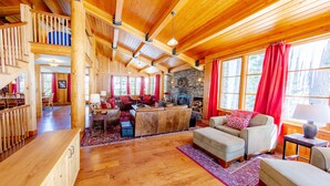 A spacious wooden cabin with a cozy living area, dining space, and a stone fireplace. - Perle du Bois - Ski in/Ski out (Kirkwood)