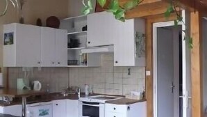 A compact kitchen with white cabinets, a wooden countertop, and a small dining table. - Serre-chevalier 1200, briançon, light runway, comfort, amenities  (Briançon)