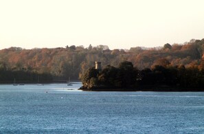 Explore the tranquil lakeside setting, featuring a historic tower and lush surroundings.